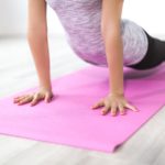partial image of woman on doing yoga pose on a yoga mat r/t healthy lifestyle
