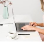 Woman at desk on laptop r/t financial health