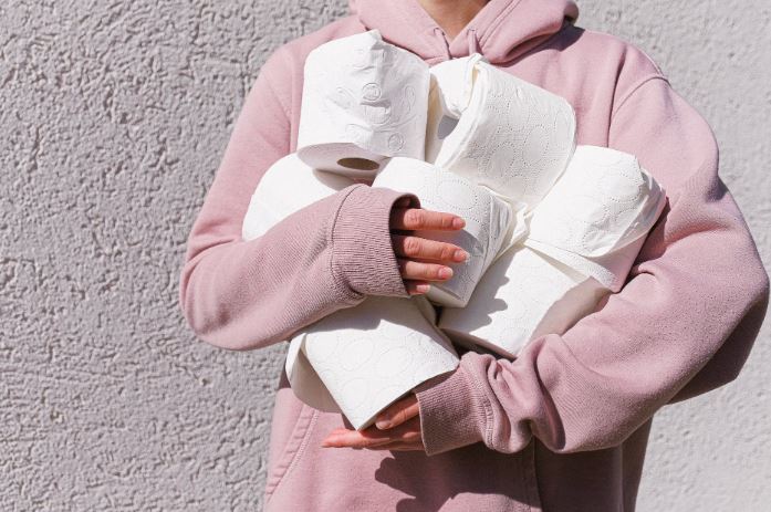 Close-up of person holding arms full of toilet paper r/t coronavirus outbreak.