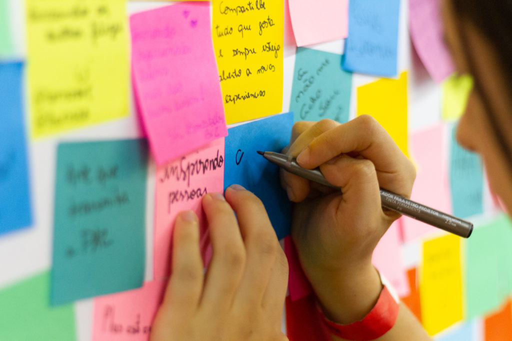 Girl writing on sticky notes r/t side hustle.
