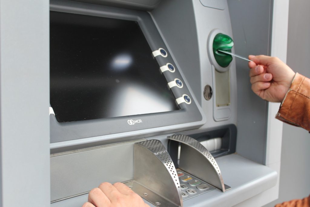 Person using ATM r/t money.
