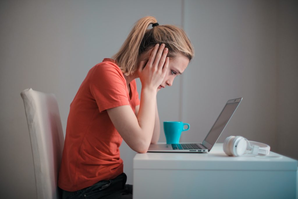 Frustrated woman sitting in front of laptop r/t earn money online