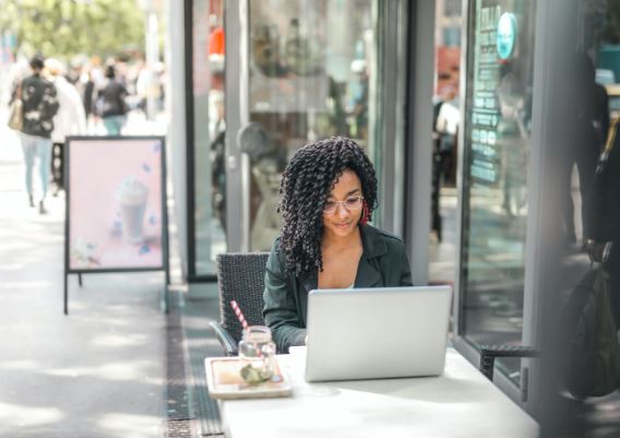 woman sitting outside using laptop r/t earn money online