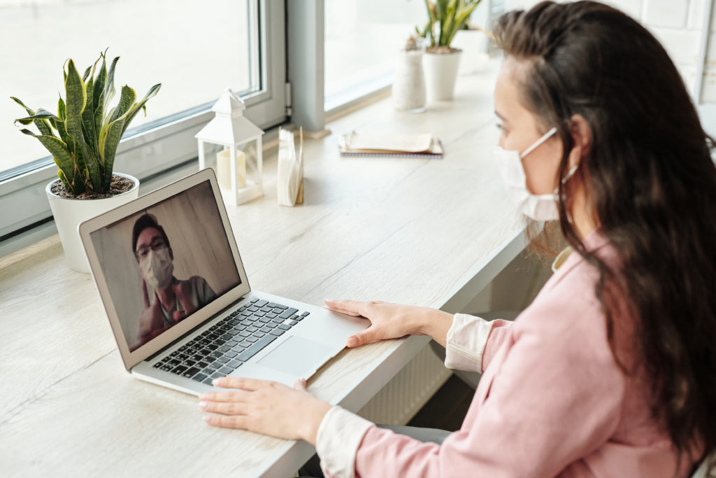 Woman wearing mask on while video chatting.